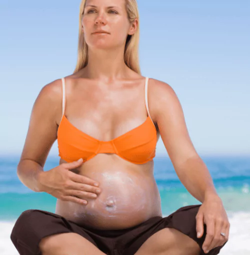 pregnant woman on beach using Aethic proven sunscreen 